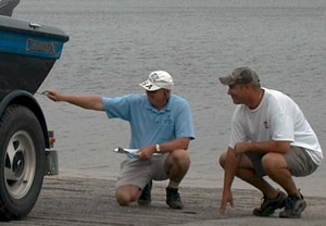 inspector and boater checking for invasive aquatic plants