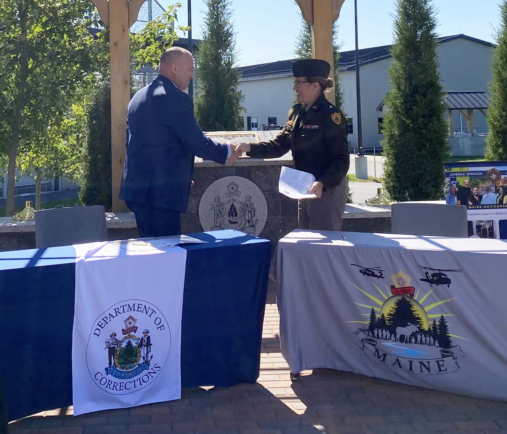 Commissioner Randall A Liberty and Brigadier General Diane Dunn shake hands