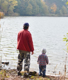 Father and son by a lake.