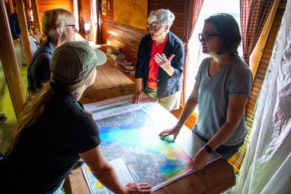 Four women talking while looking at a map